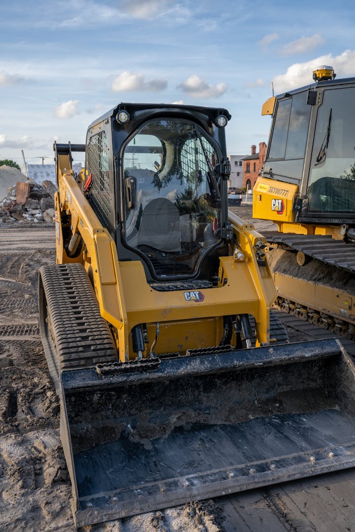 About Close-up of a yellow compact track loader on a construction site during daytime.